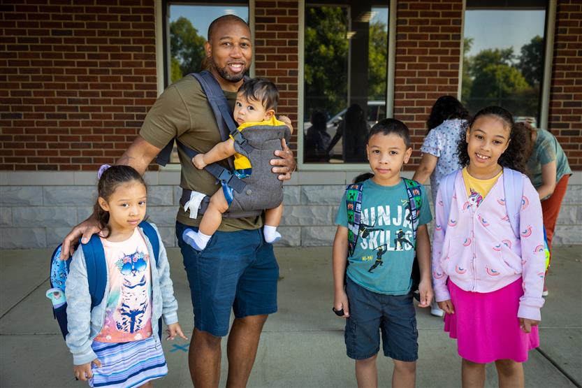 A family smiles on the first full day of kindergarten